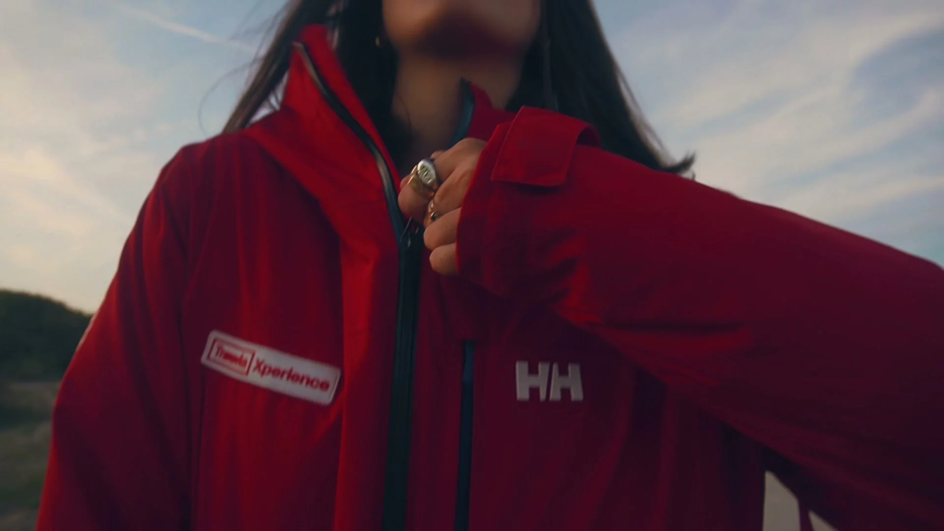 Chica con chaqueta roja de esquí de Transvia en la playa, fotograma de la campaña de invierno
